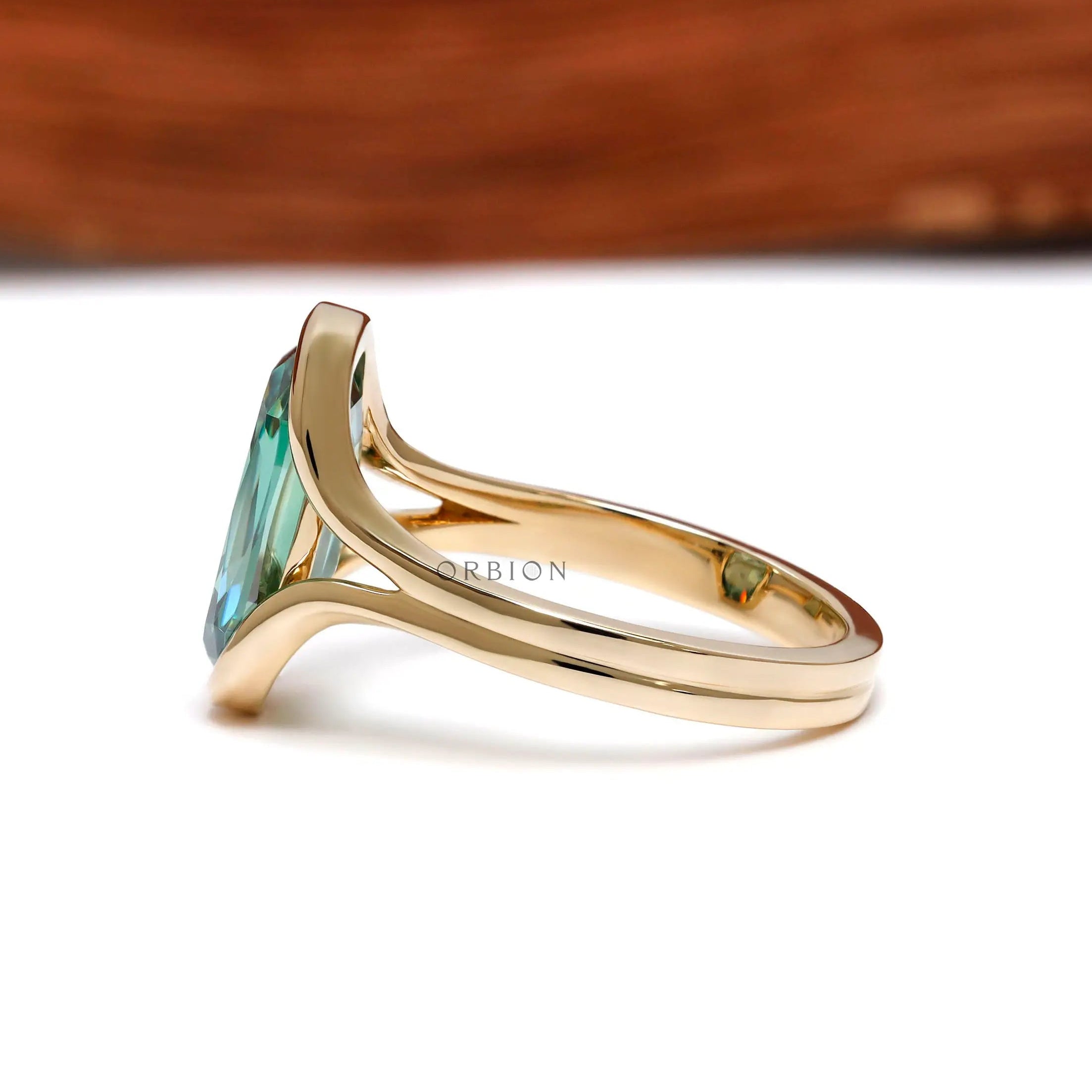 Side view of floating half bezel green moissanite ring