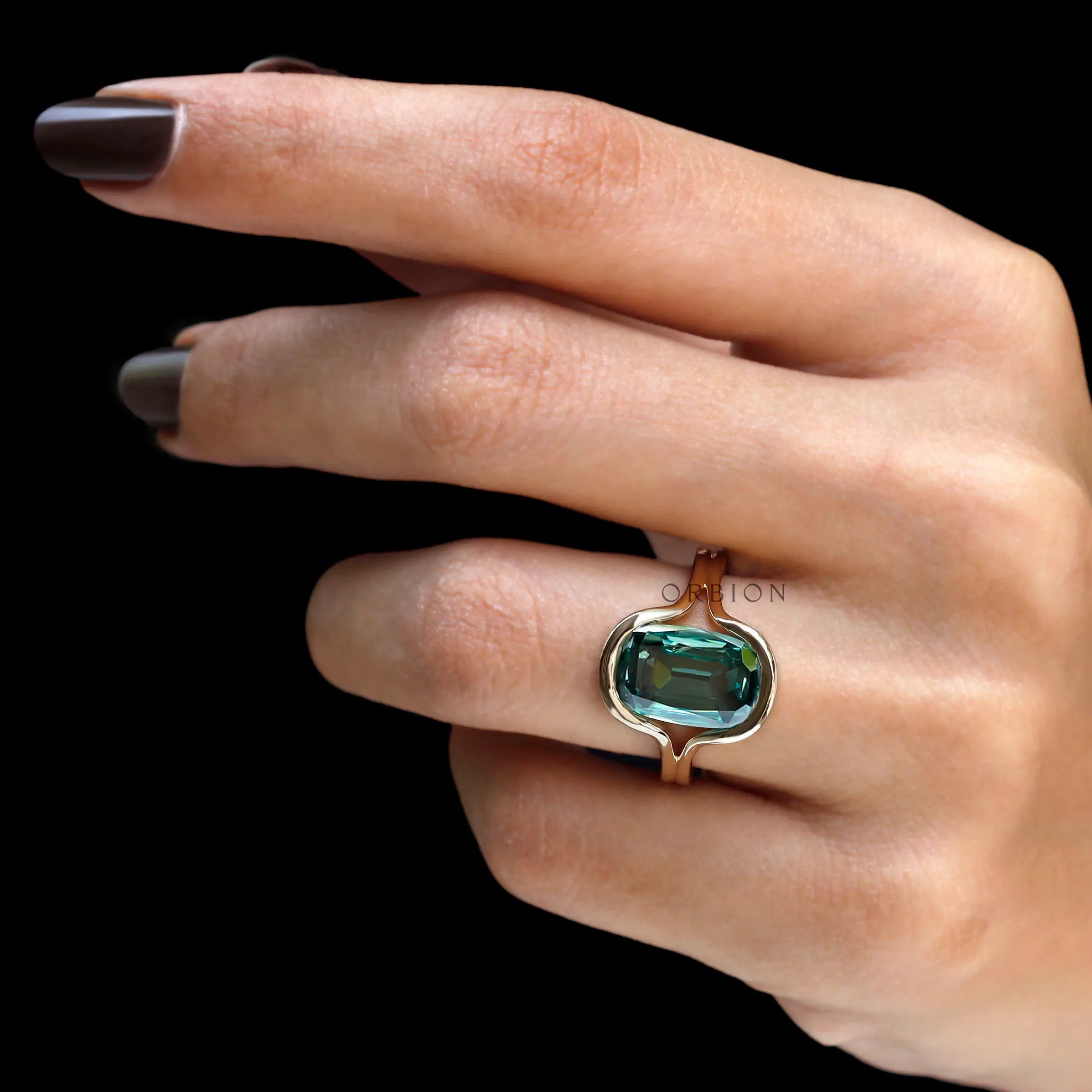 Top worn view of elongated green moissanite bezel ring