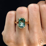 Close-up worn view of green moissanite floating bezel ring