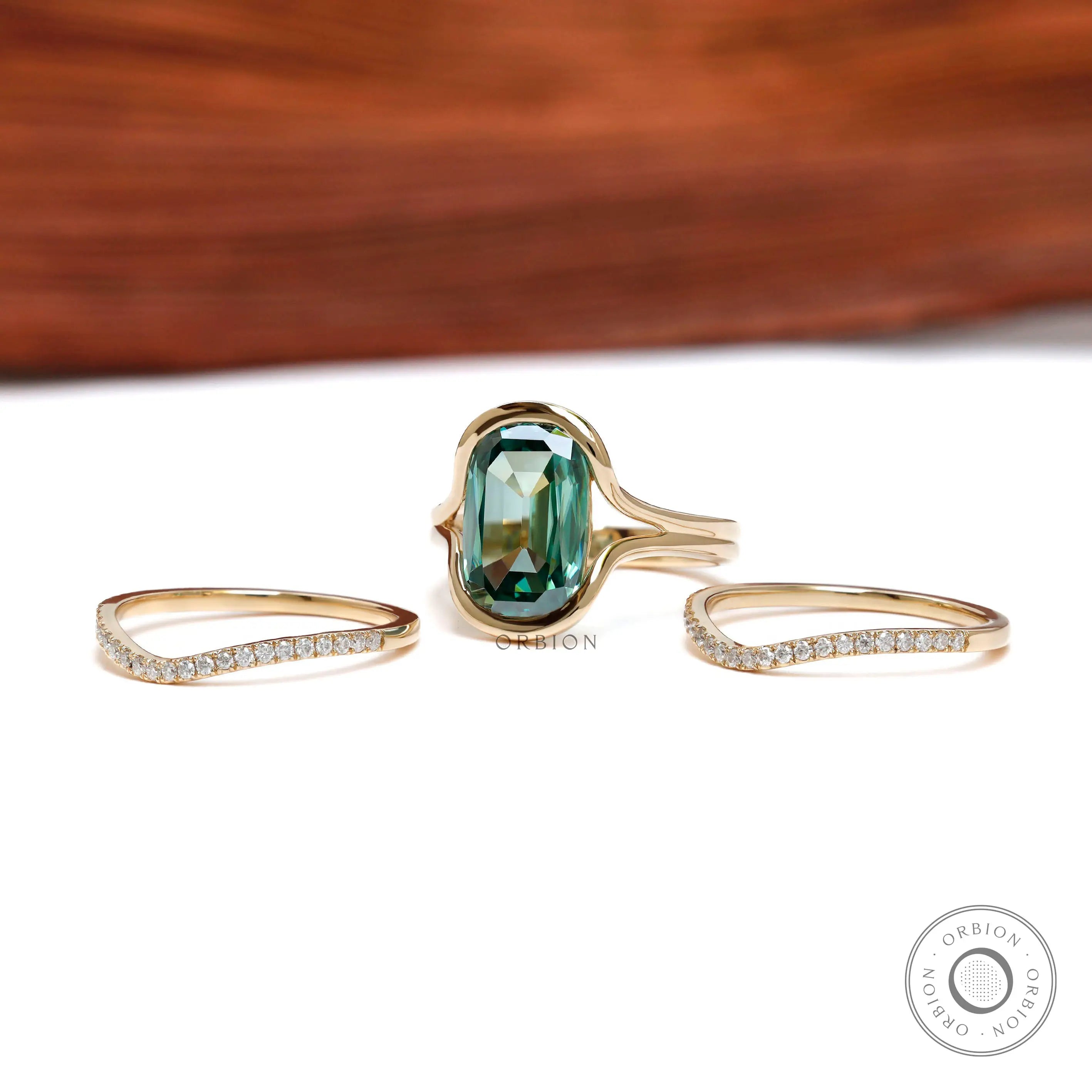 Angled view of elongated cushion green moissanite ring set in yellow gold