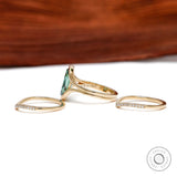 Side profile of green moissanite ring set with curved bands