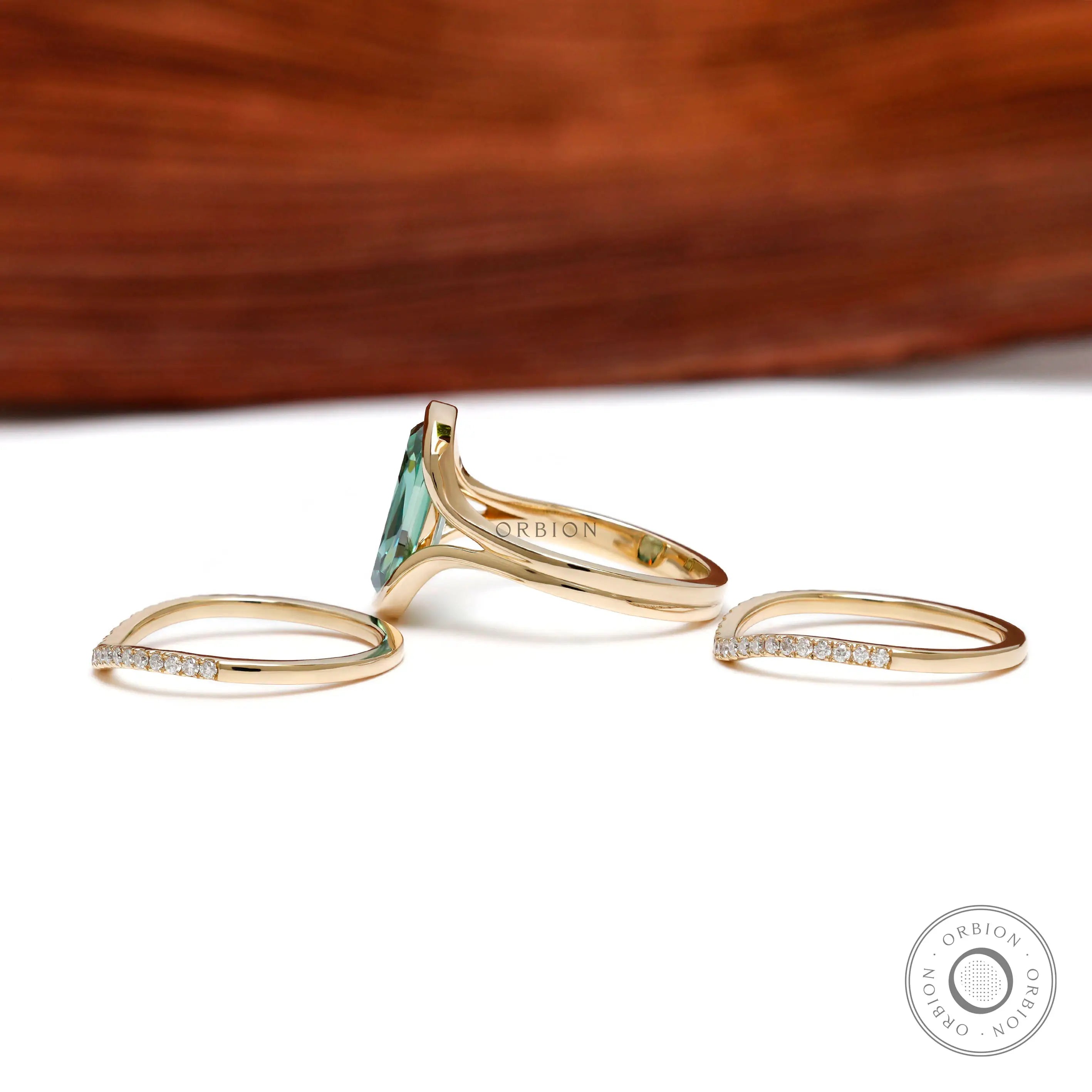 Side profile of green moissanite ring set with curved bands