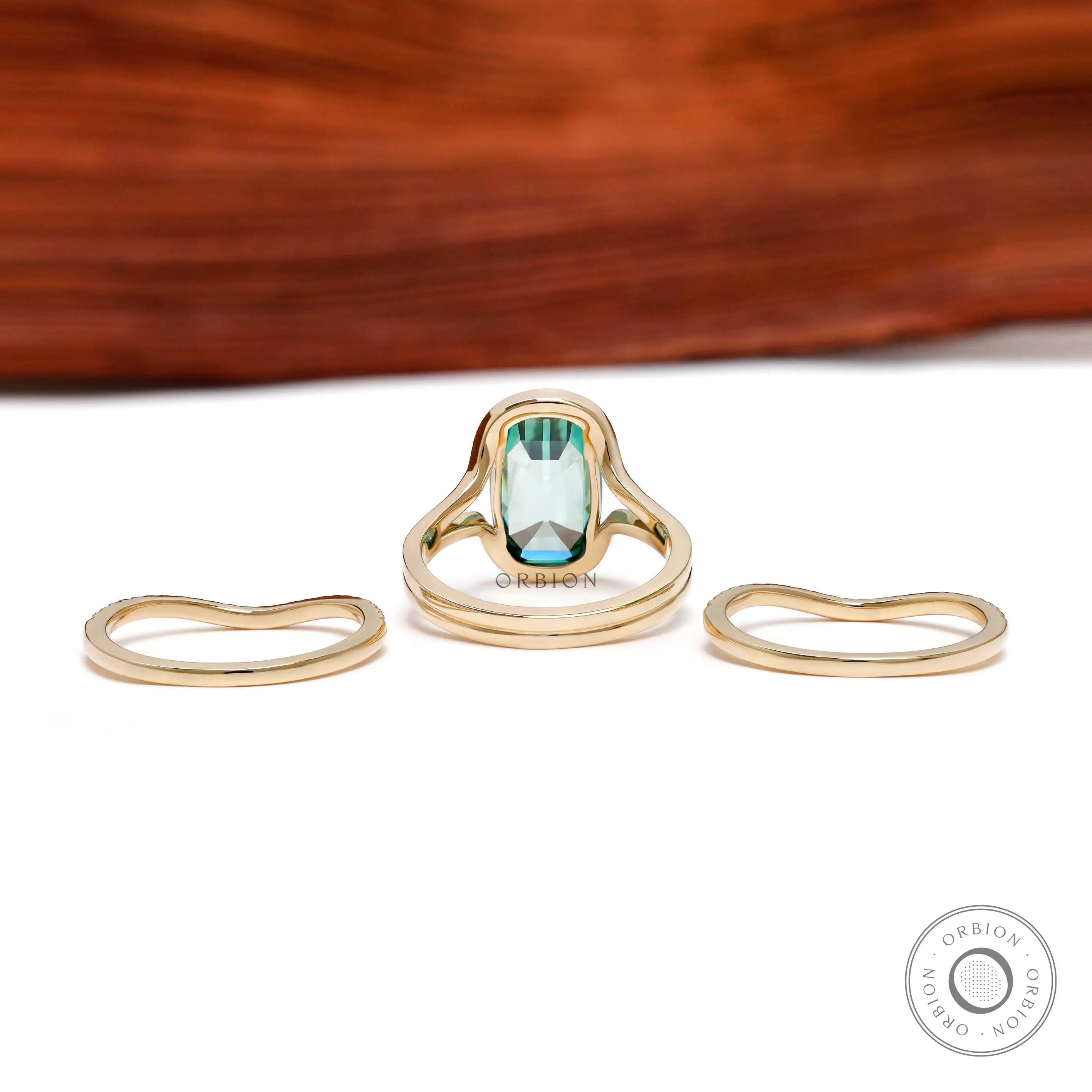 Back view of green moissanite ring set with curved matching bands