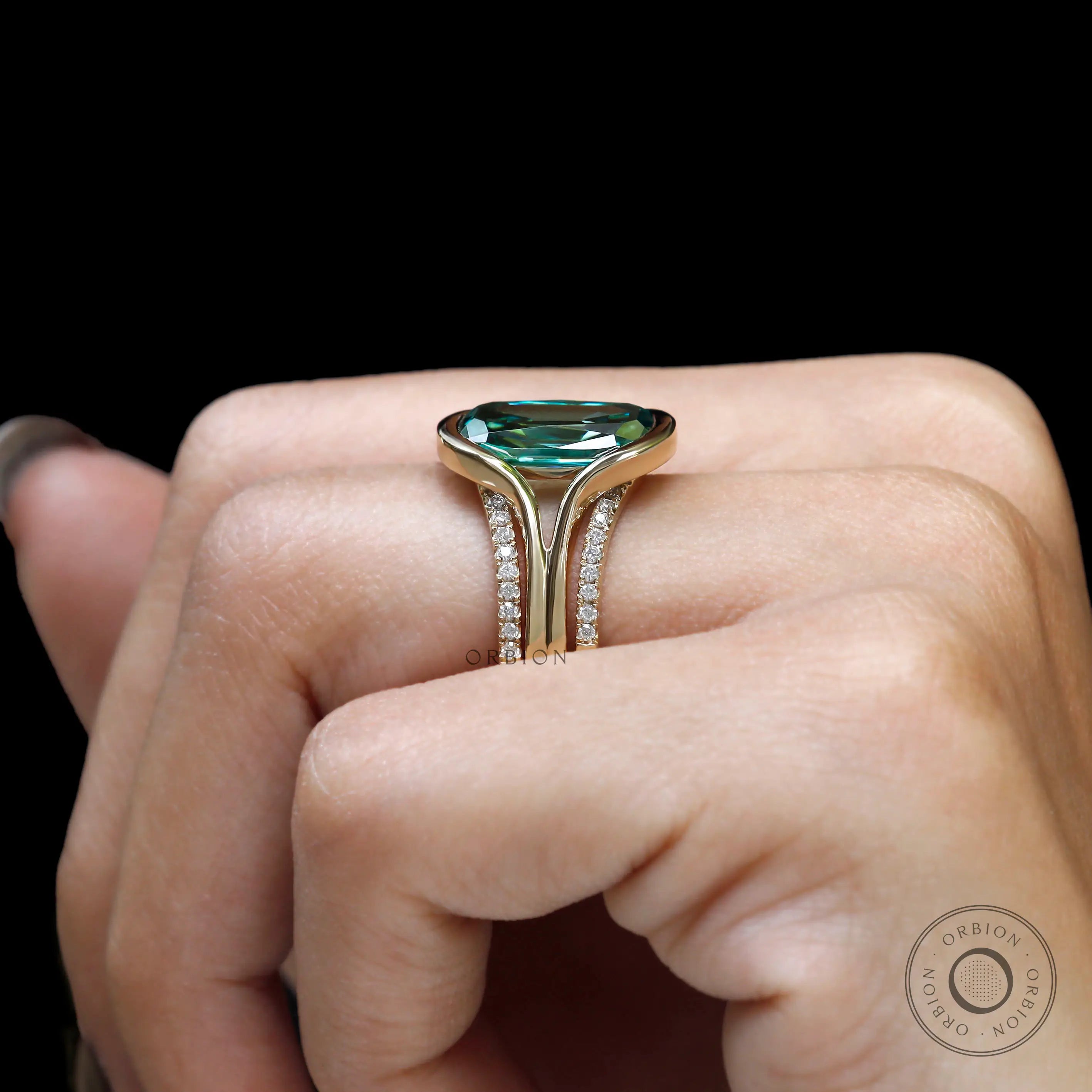 Top view of elongated cushion green moissanite ring set on hand