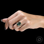 Side close-up of green moissanite ring set worn on finger