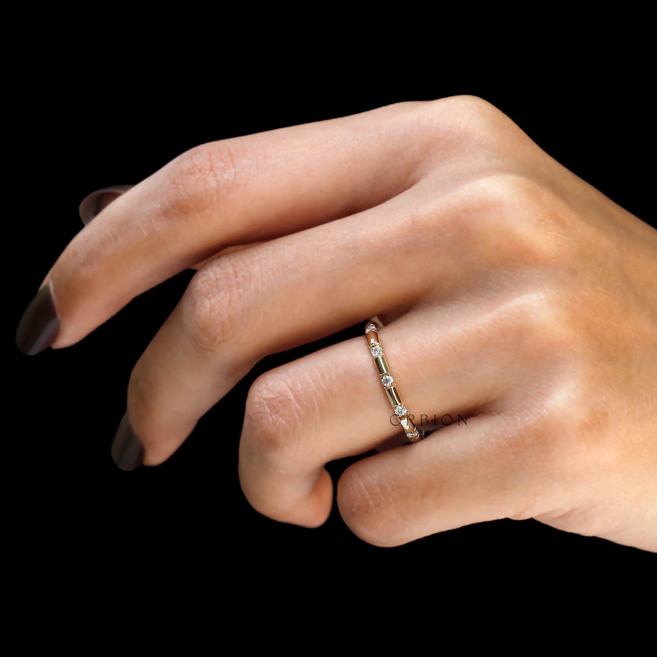 Yellow gold lab diamond distance wedding band on finger