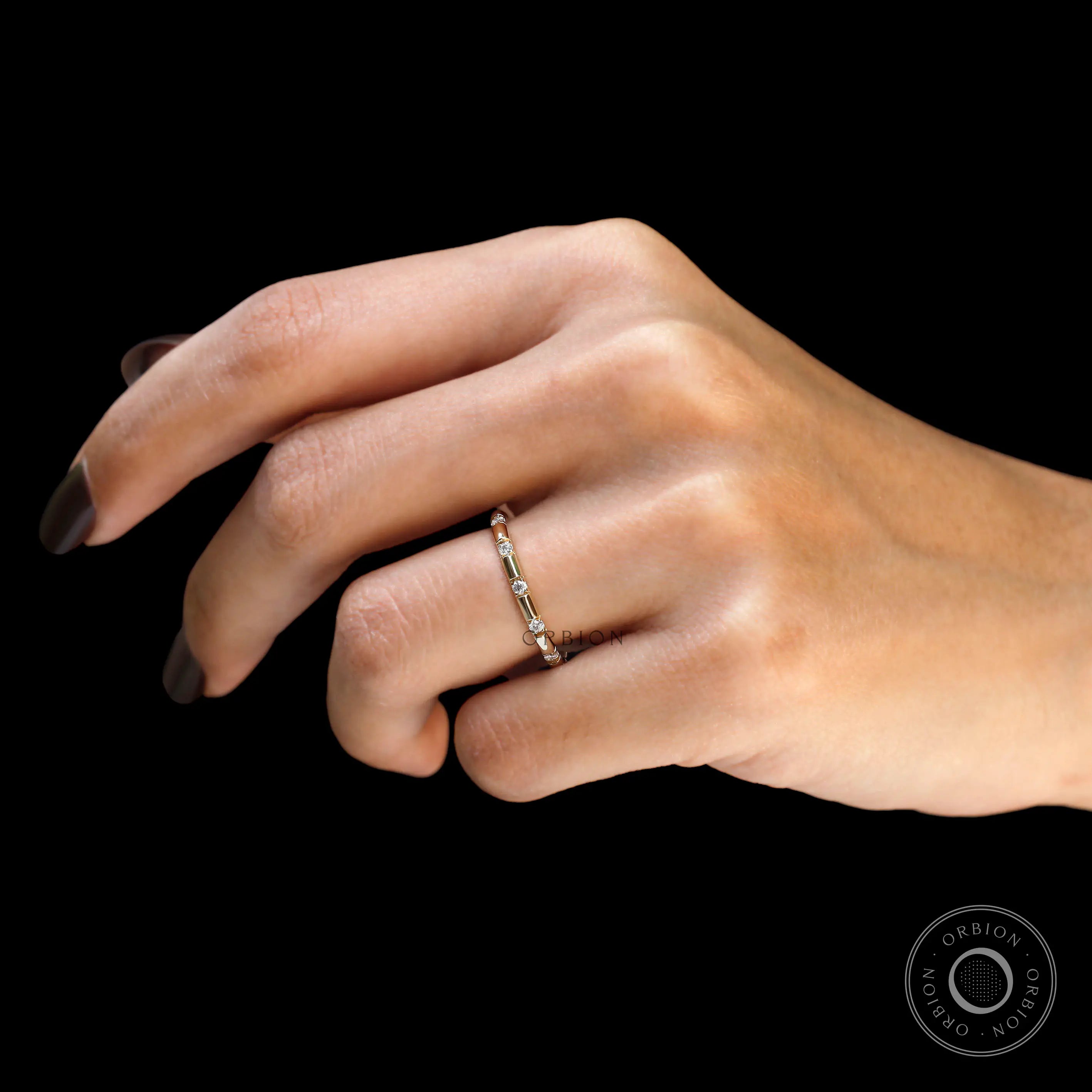 Yellow gold lab diamond distance wedding band on finger