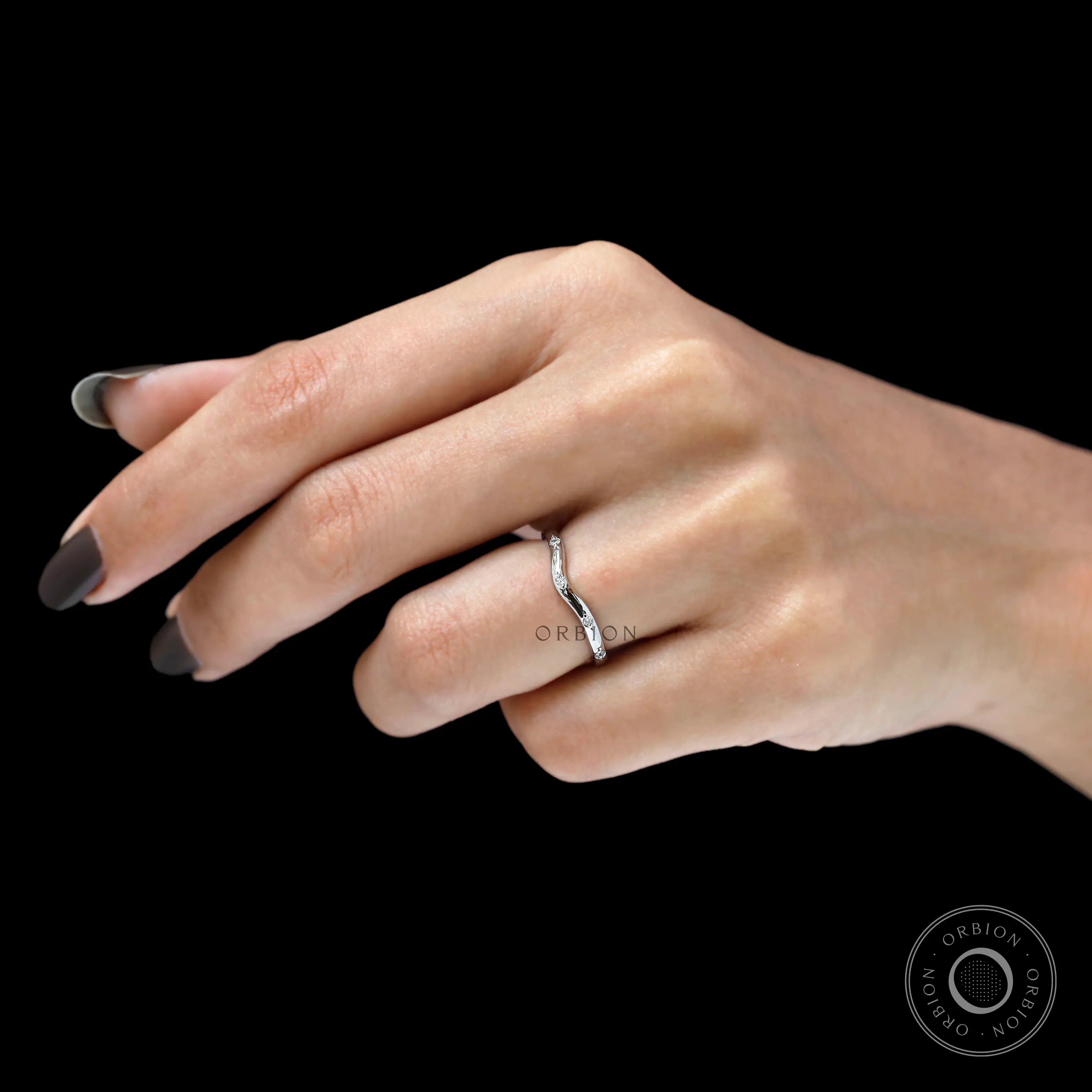 Minimalist curved diamond ring worn on finger