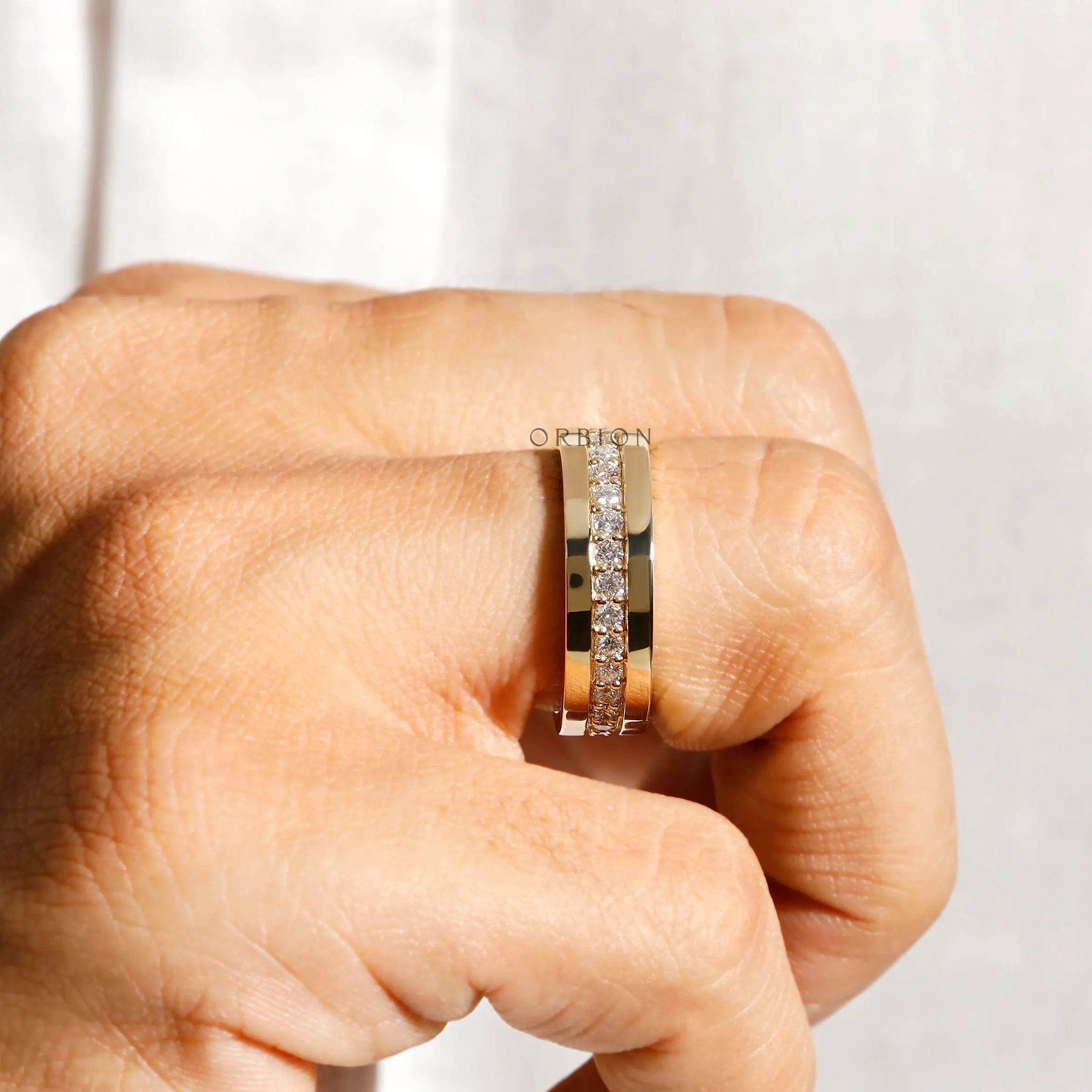Mens yellow gold lab diamond band on finger close up