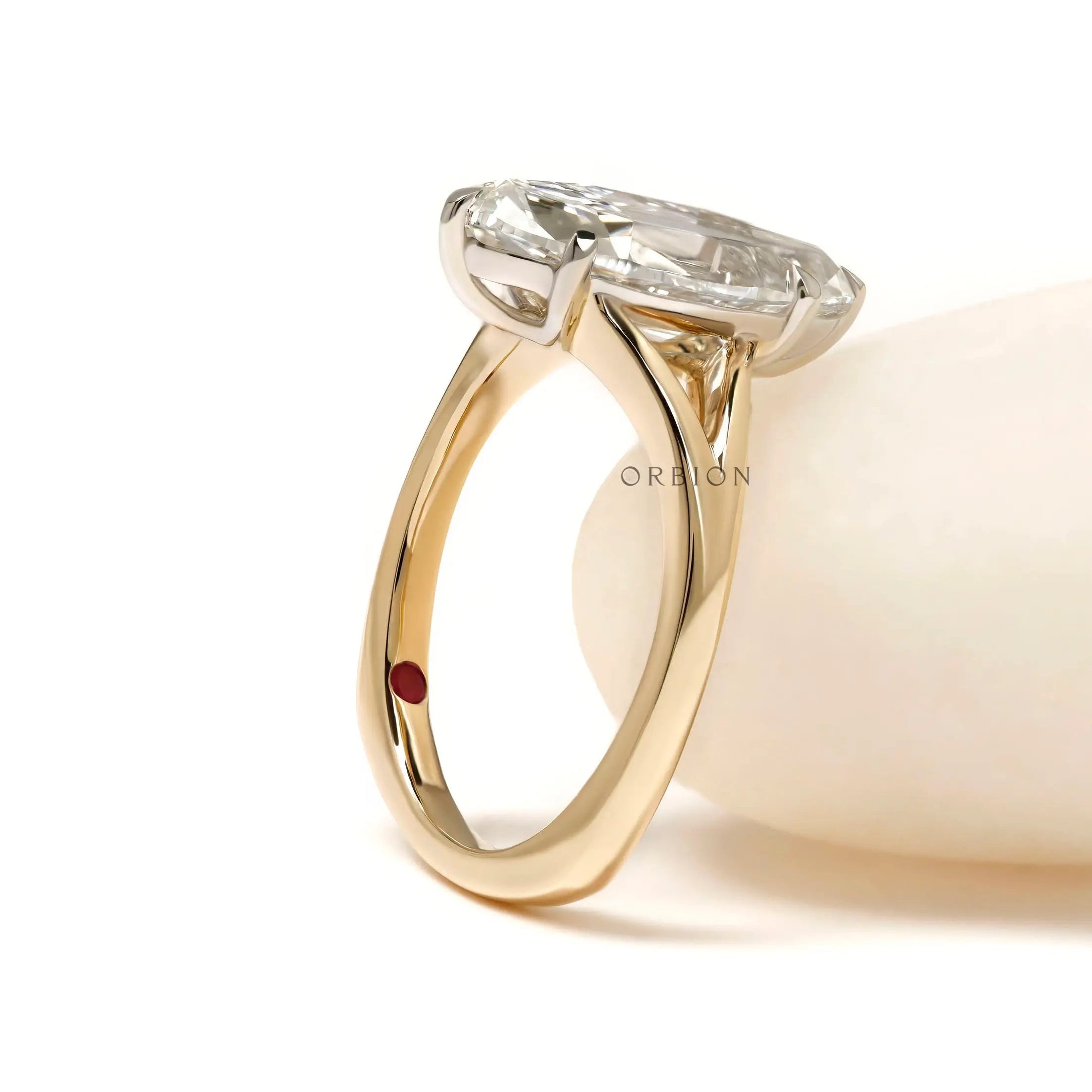 Moval engagement ring with hidden ruby inseam stone