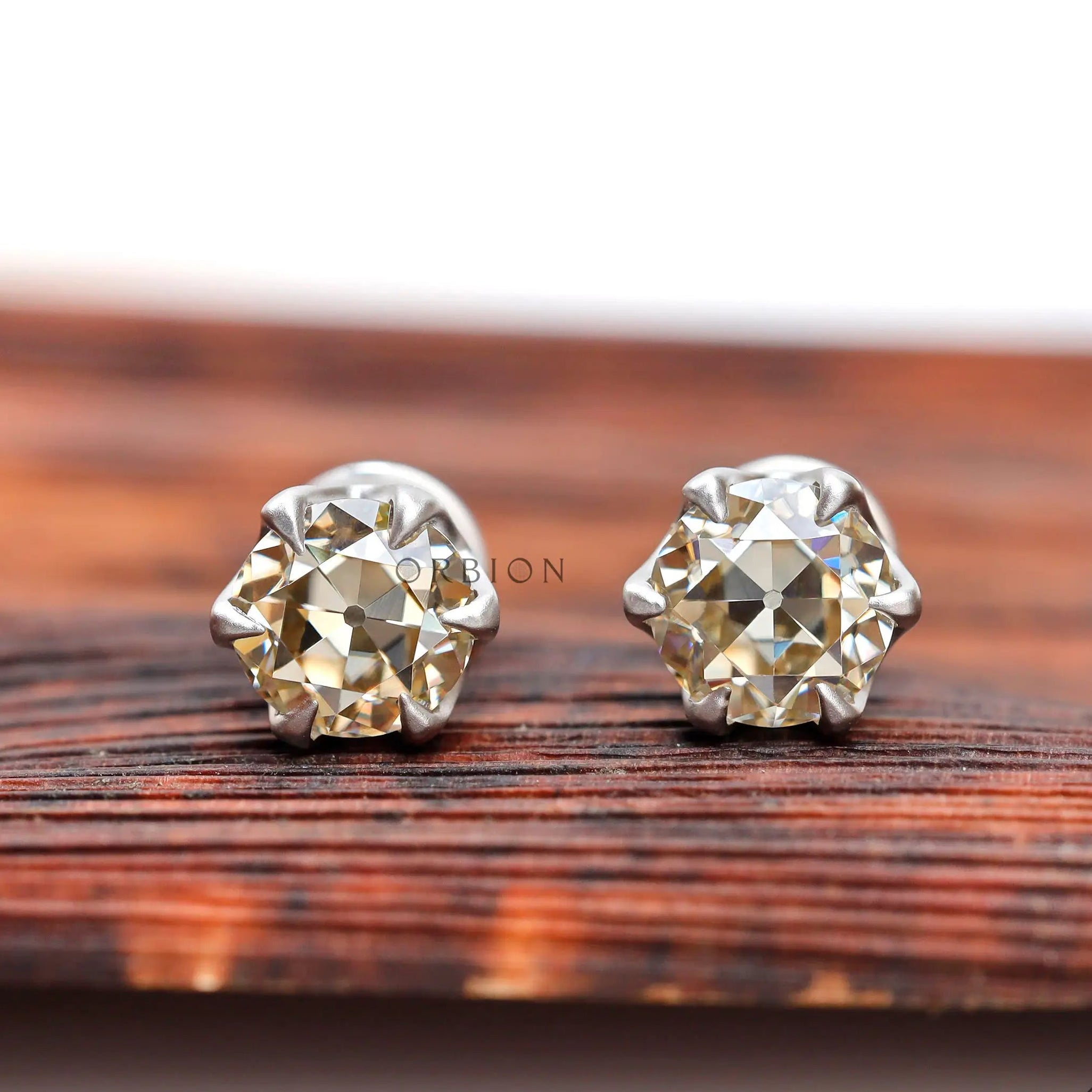 Round champagne moissanite stud earrings in 10K white gold