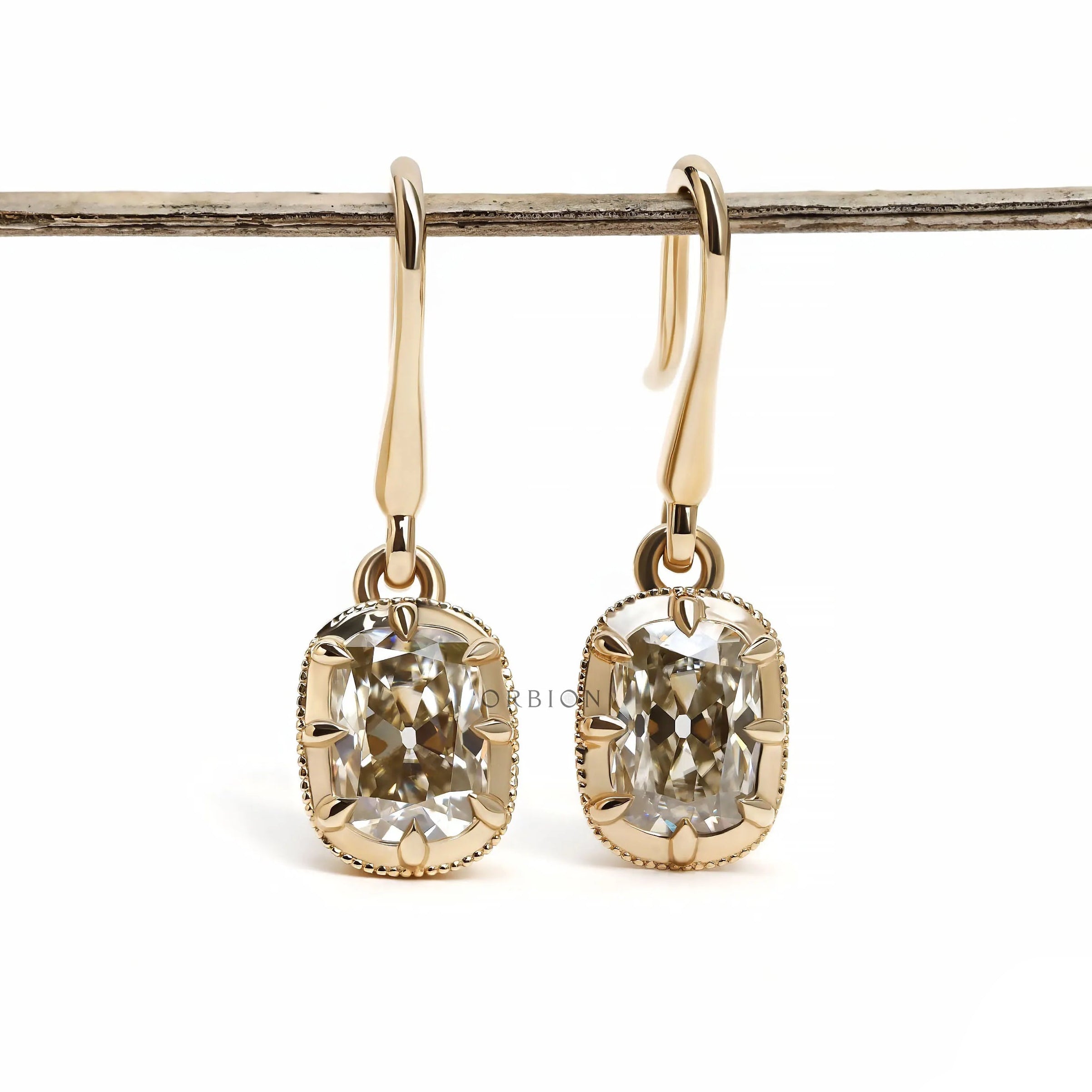 Vintage style elongated old mine cushion cut moissanite dangle drop earrings in 14k yellow gold.