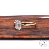 Emerald cut colorless stone ring yellow gold