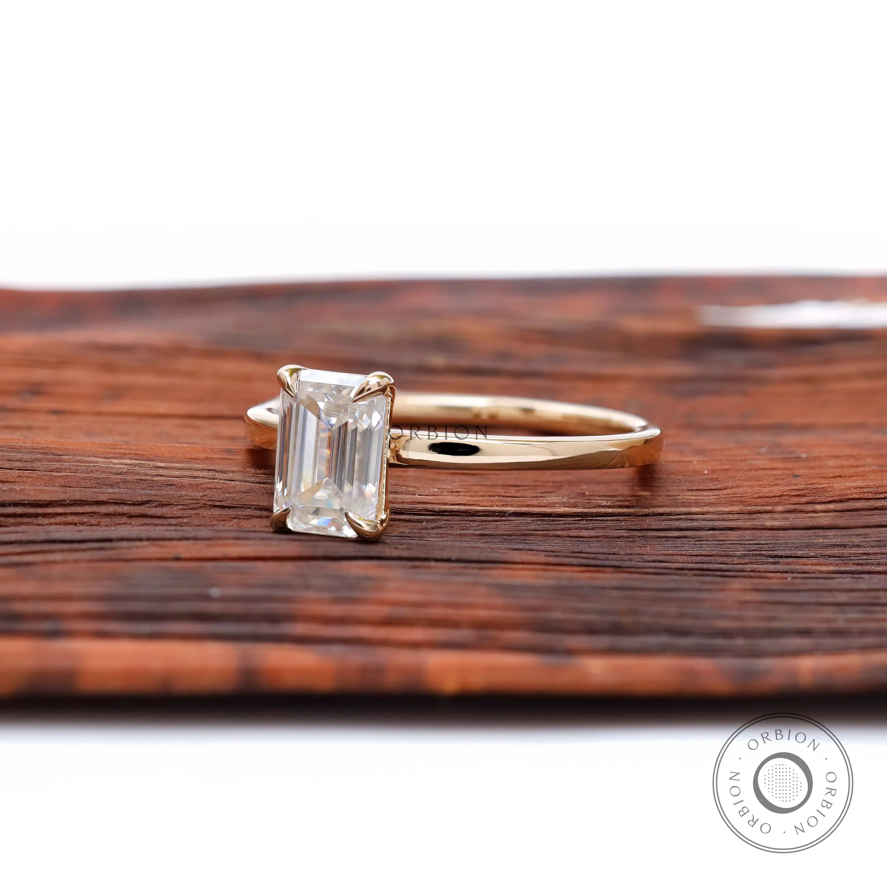 Emerald cut colorless stone ring yellow gold