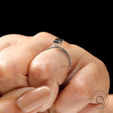 On hand profile view dainty emerald cut grey moissanite