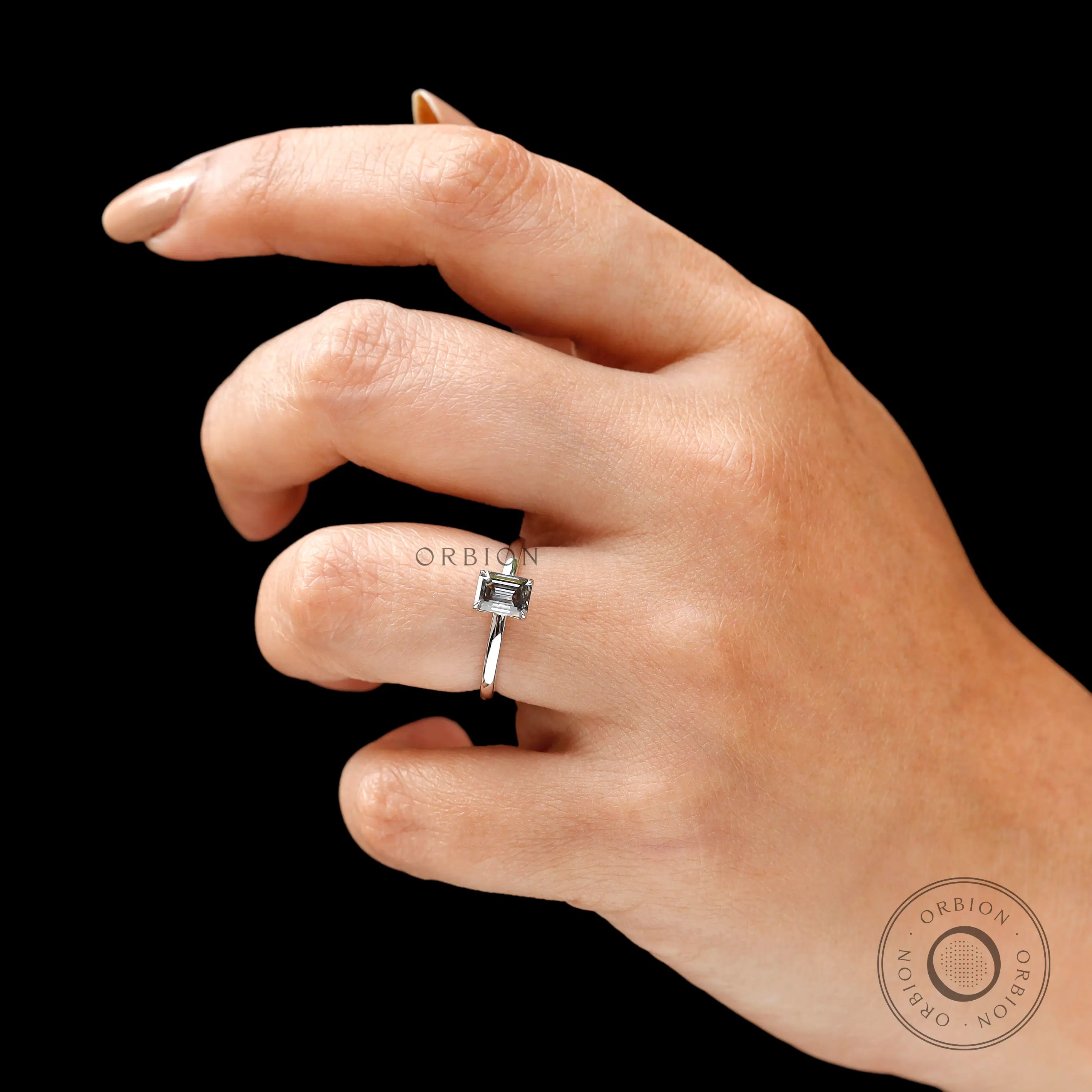 On hand top view emerald cut grey moissanite solitaire