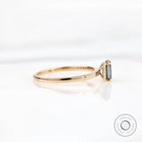 Thin band emerald cut grey moissanite ring side angle