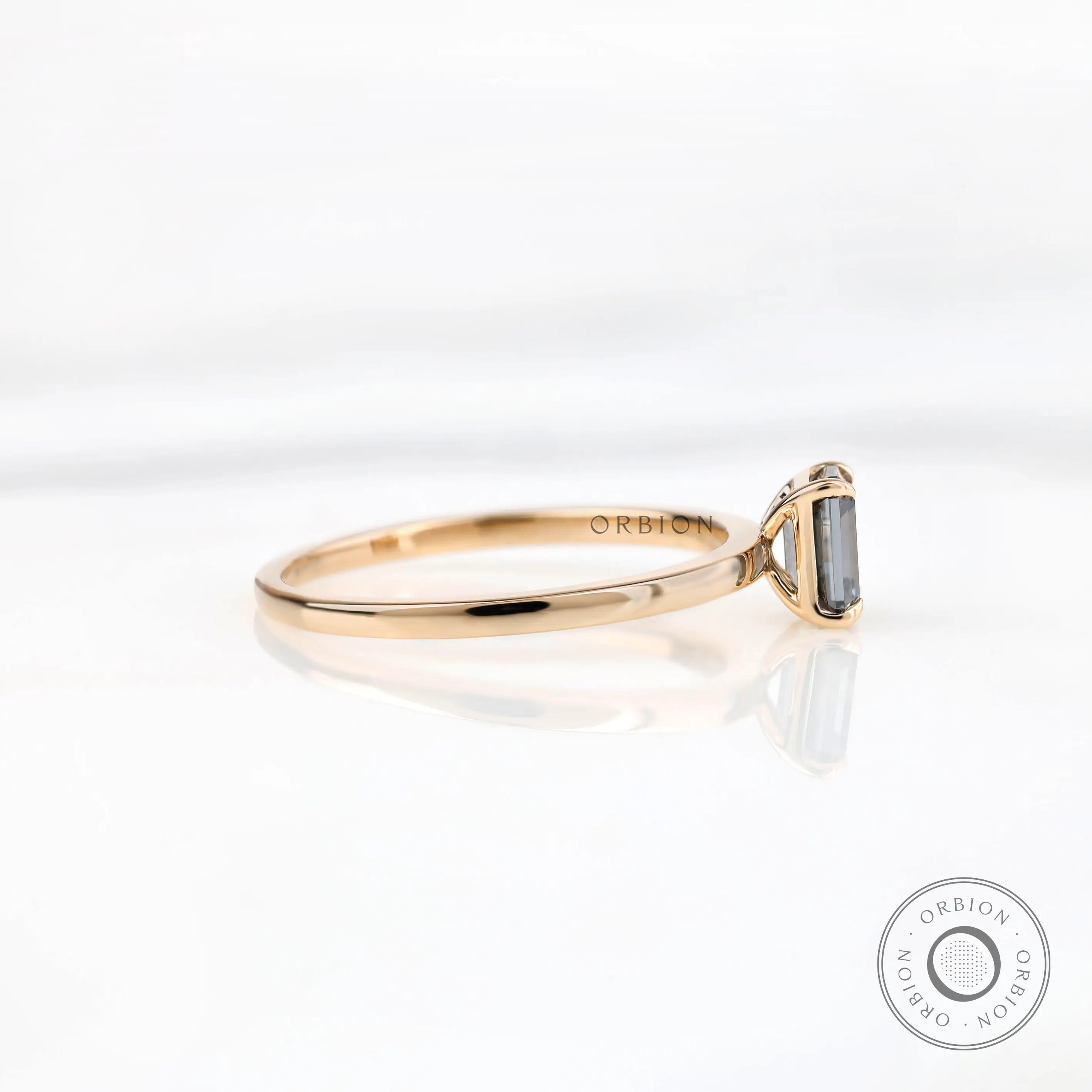 Thin band emerald cut grey moissanite ring side angle