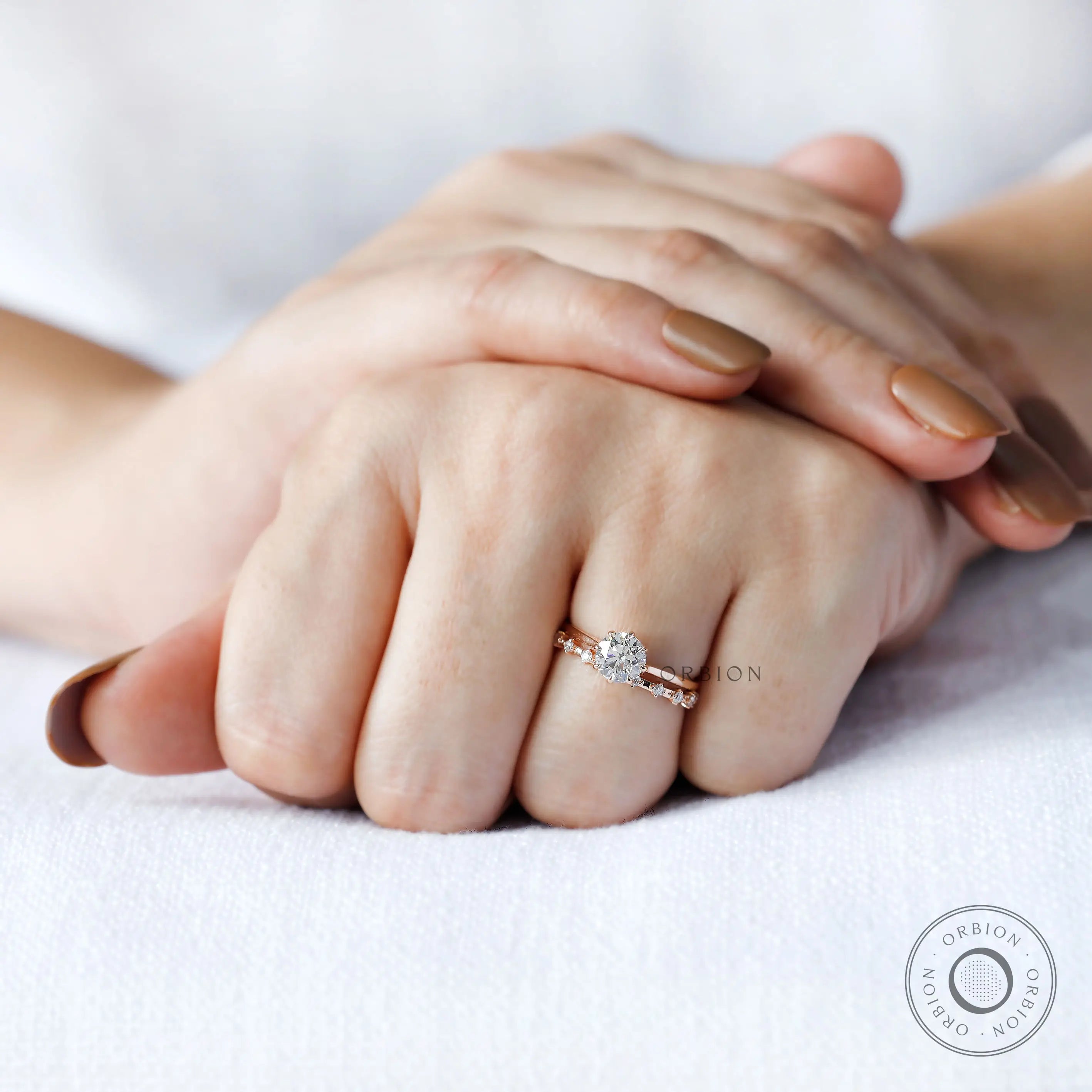 On-hand view of cathedral style round diamond engagement ring