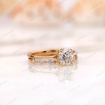 Angled view of round diamond engagement ring with pavé band