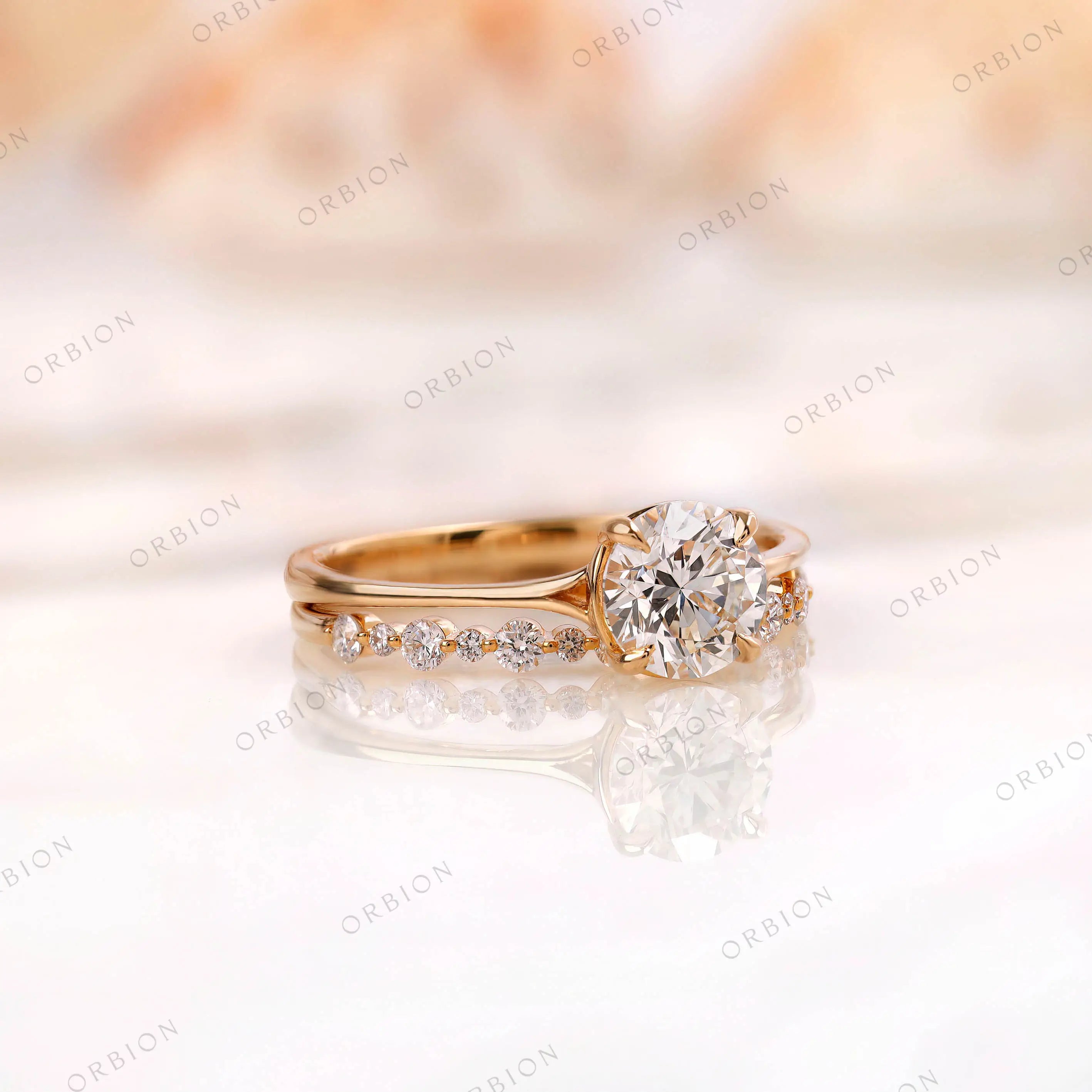 Angled view of round diamond engagement ring with pavé band