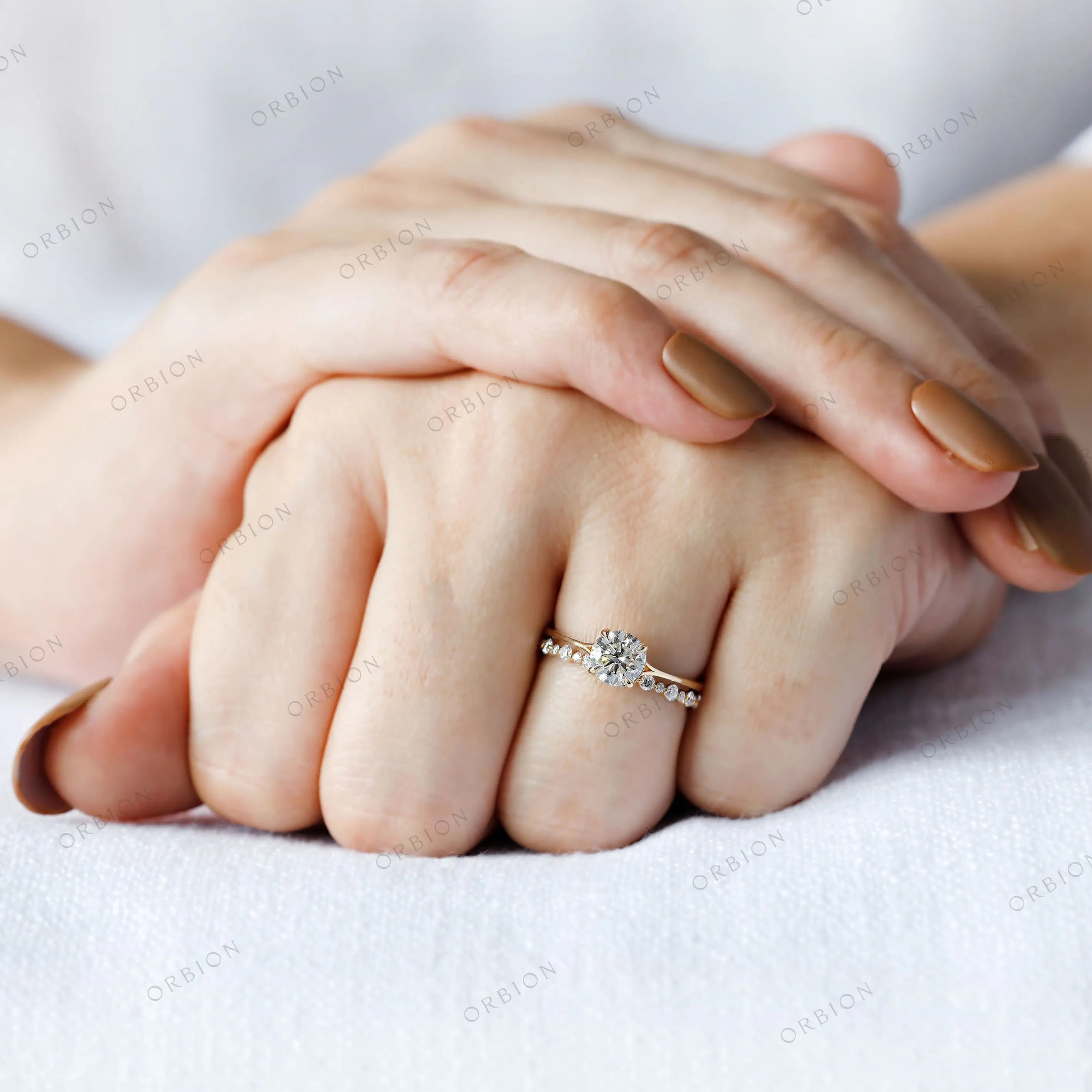 Round brilliant diamond ring worn on hand for scale