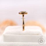 Bezel set cushion diamond ring displayed upright