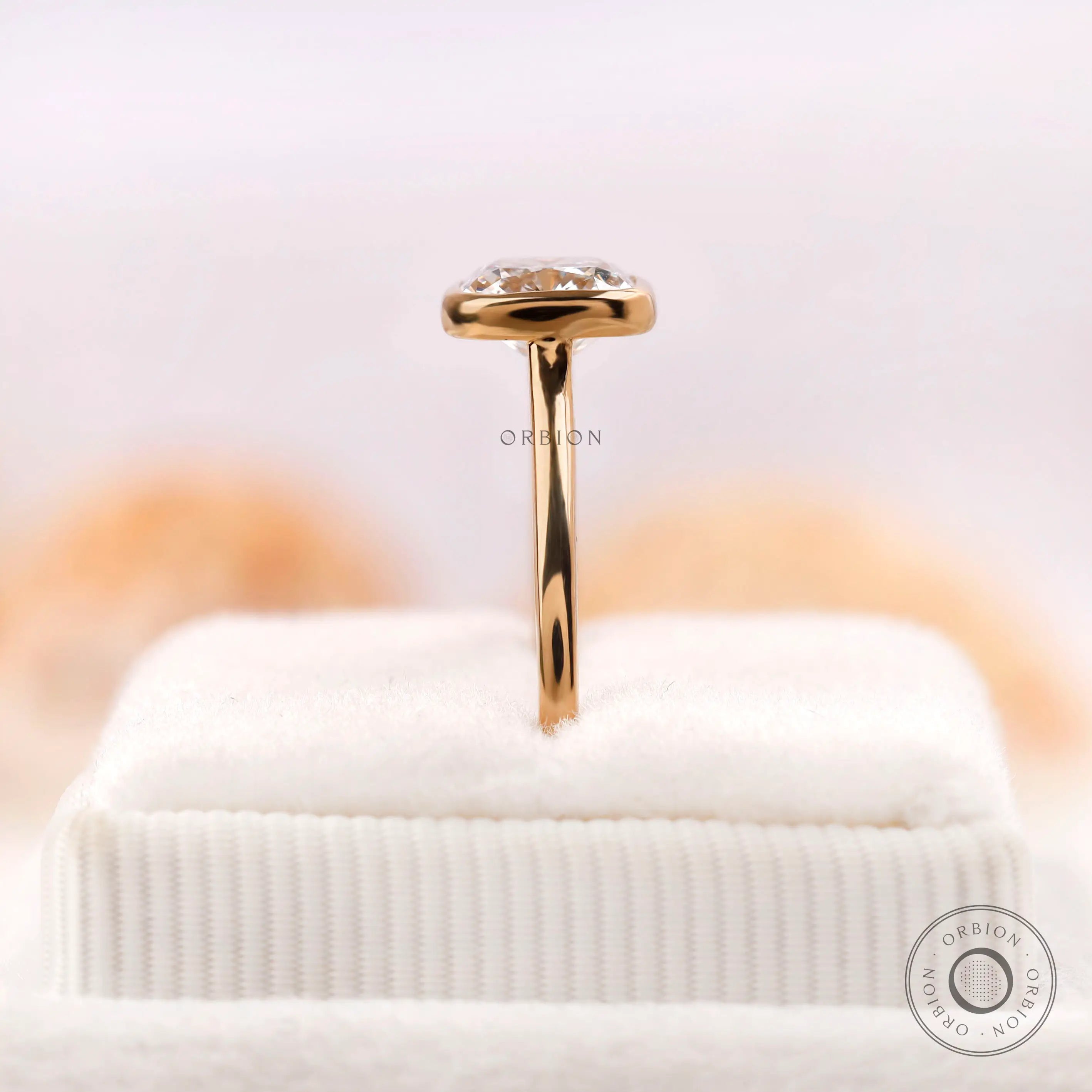 Bezel set cushion diamond ring displayed upright