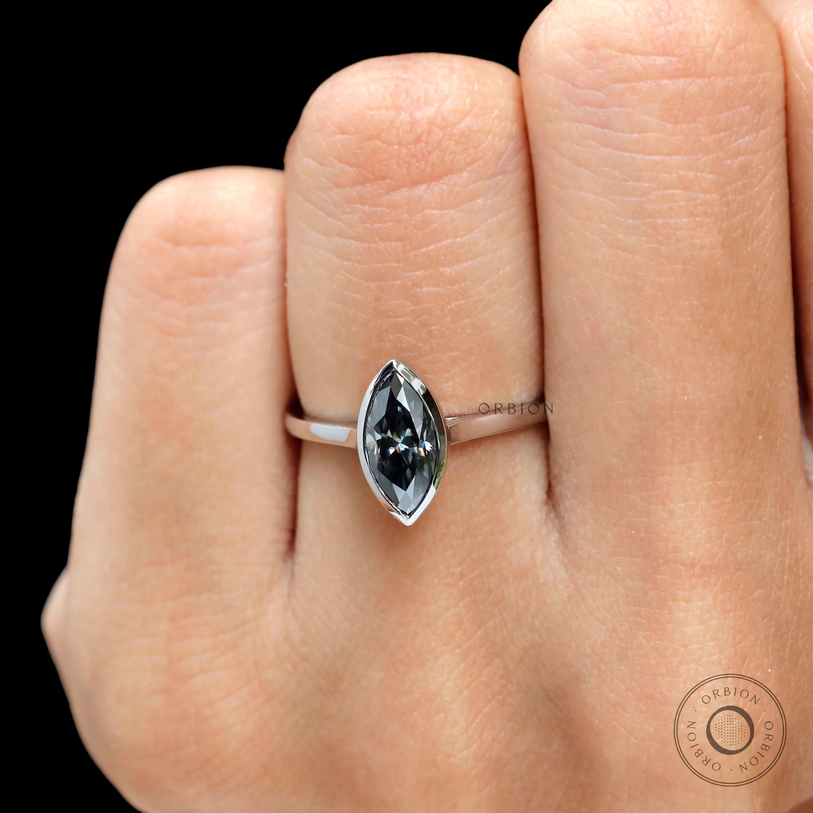Close up marquise cut grey moissanite bezel ring showing cut and facets