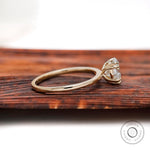 Side profile of oval moissanite ring in yellow gold