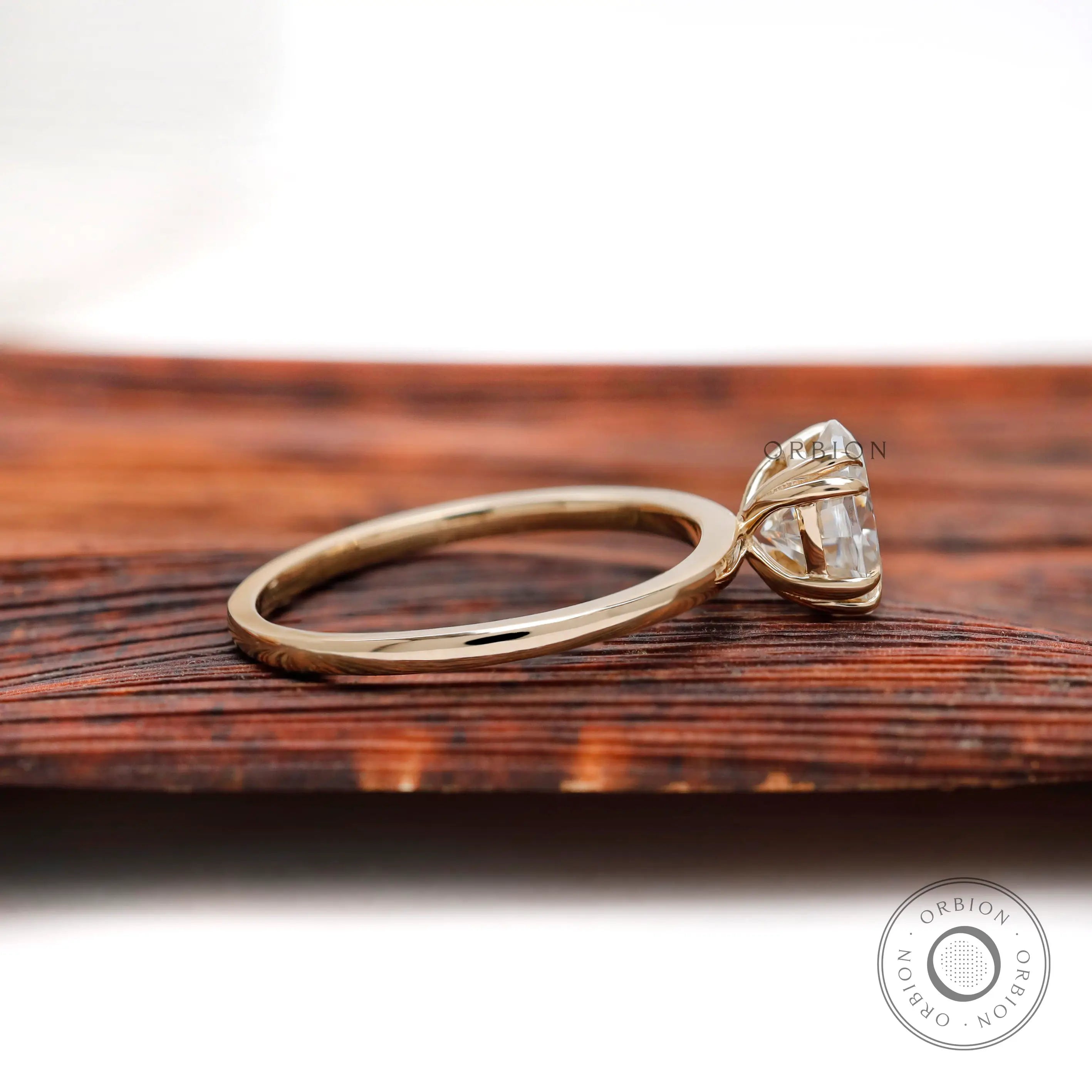 Side profile of oval moissanite ring in yellow gold