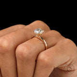 Cushion cut moissanite or lab diamond solitaire ring in yellow gold on hand