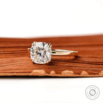 Cushion cut center stone solitaire ring, close up view showing symmetrical prong placement