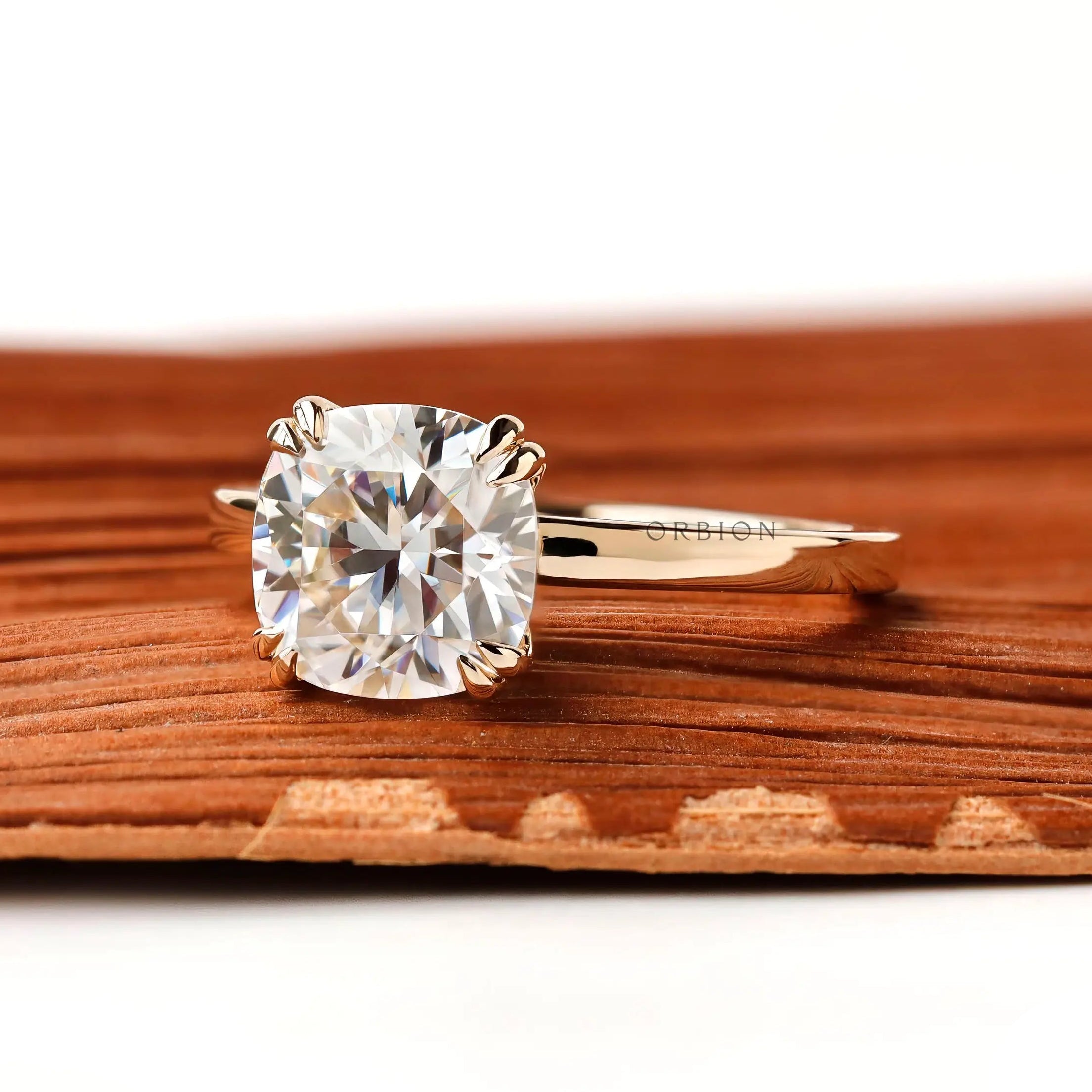 Cushion cut center stone solitaire ring, close up view showing symmetrical prong placement