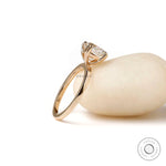 Profile view of yellow gold solitaire ring highlighting elevated prong setting and slim band