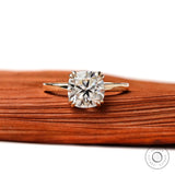 Cushion cut solitaire engagement ring in 14K yellow gold with glossy finish, front view