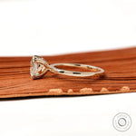 Side view of cushion solitaire ring showing cathedral shank and four prong martini setting
