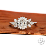 Oval cut floral solitaire engagement ring with marquise side stones