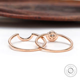 Diamond halo engagement ring set displayed on wooden surface