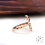 Side profile of rose gold snake ring with diamond accents