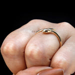 Minimalist gold snake ring photographed on finger