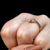 Minimalist gold snake ring photographed on finger