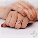 Oval diamond cluster engagement ring worn on hand