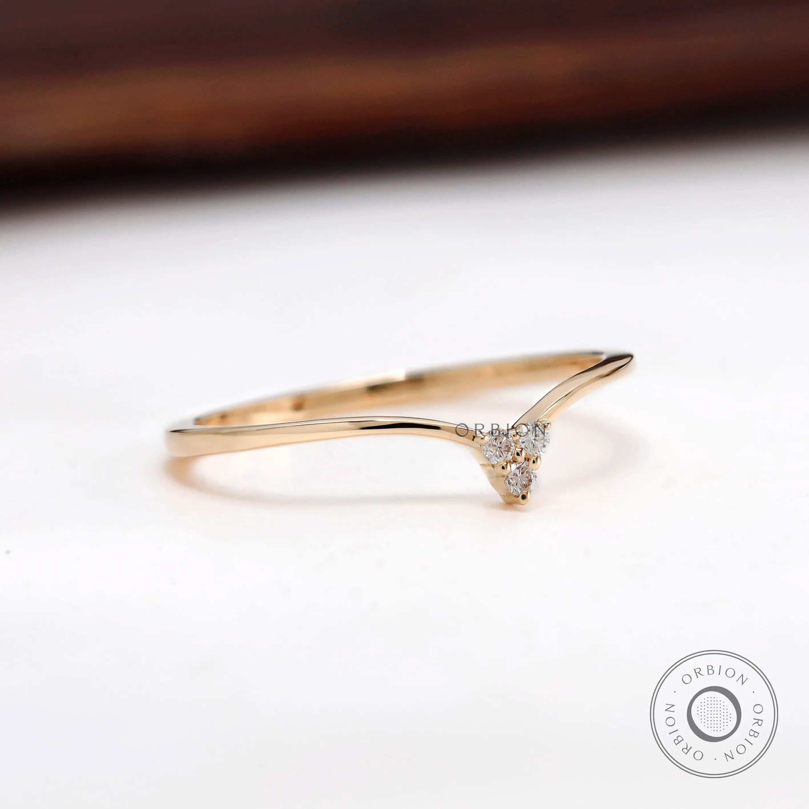Side angle of chevron diamond wedding band in yellow gold