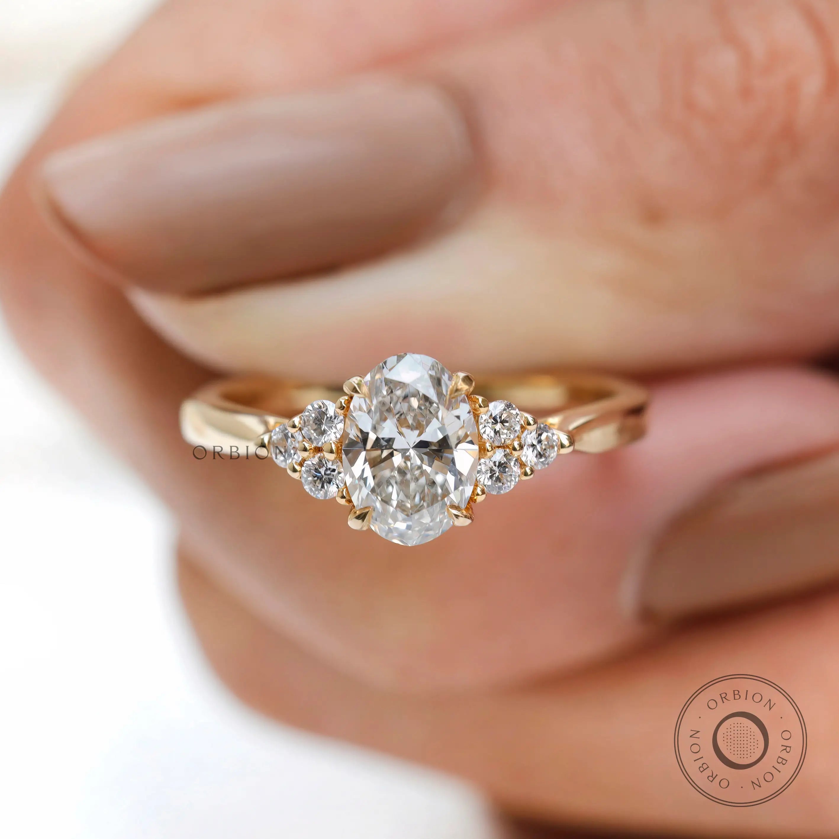 Close-up of oval diamond cluster setting with round accent stones