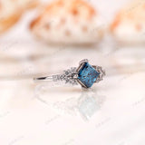 Cluster style engagement ring with blue princess cut diamond and moissanite accents