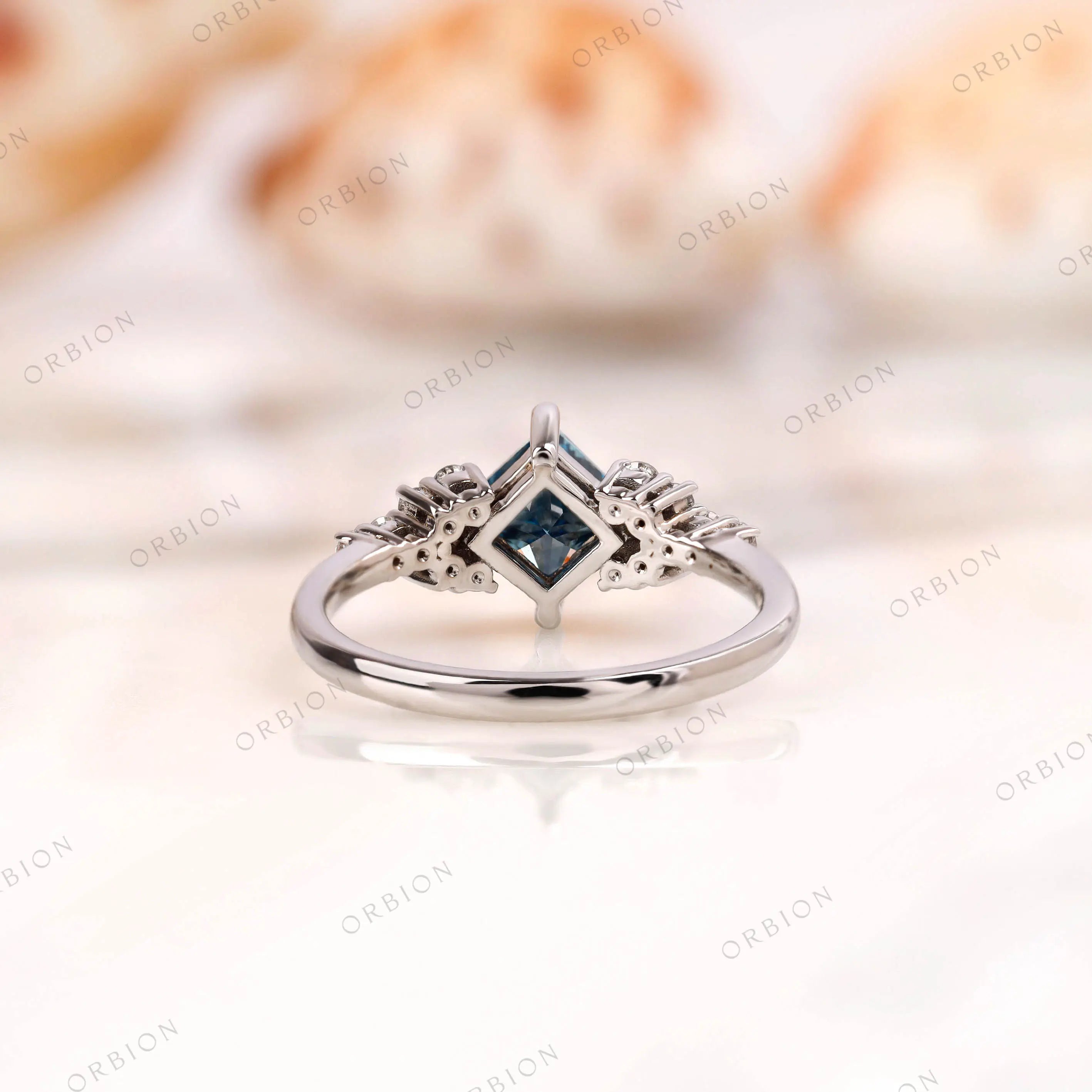 Under-gallery detail of princess cut blue diamond cluster ring