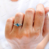 On-hand view of cluster style blue diamond engagement ring