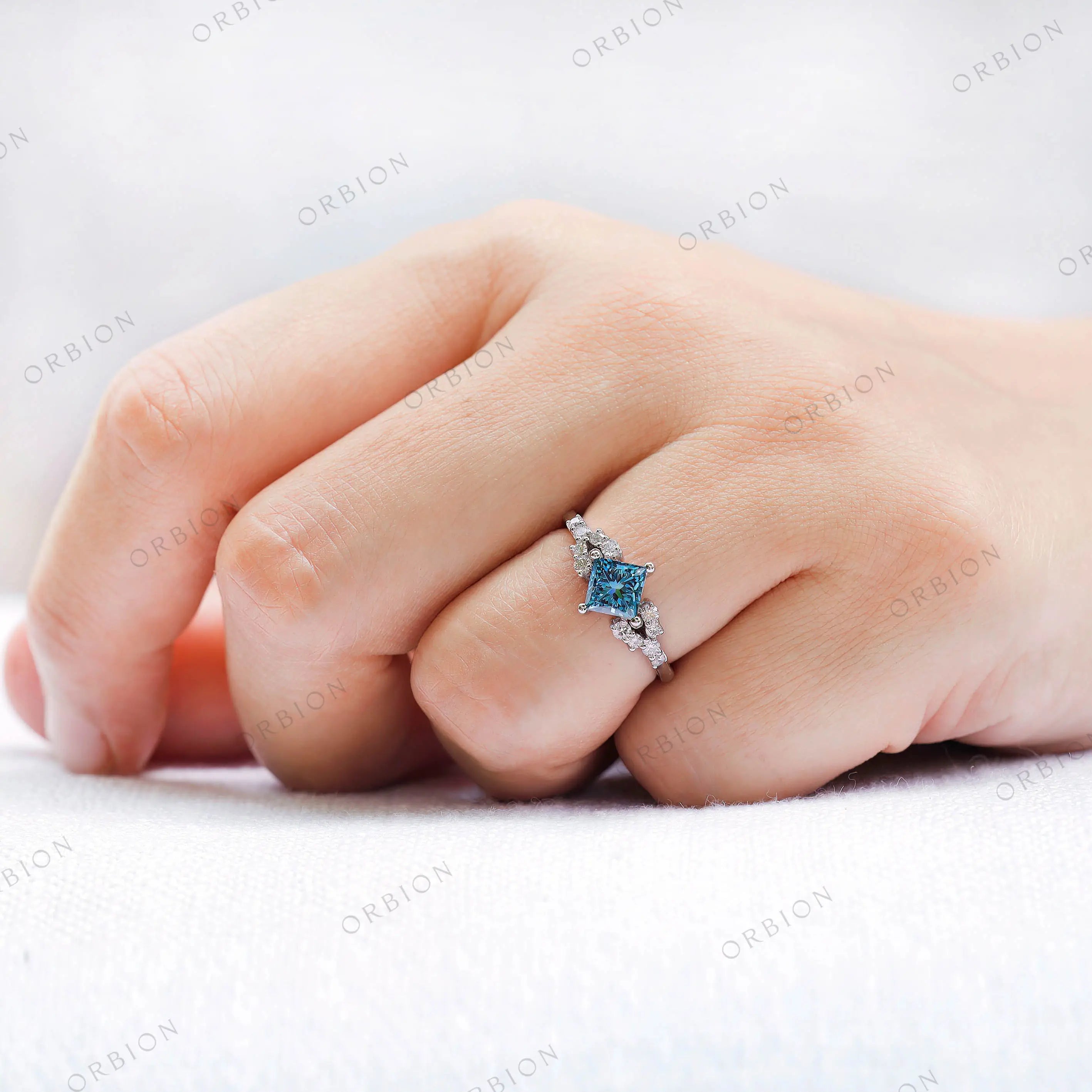 Top view of princess cut blue diamond cluster engagement ring