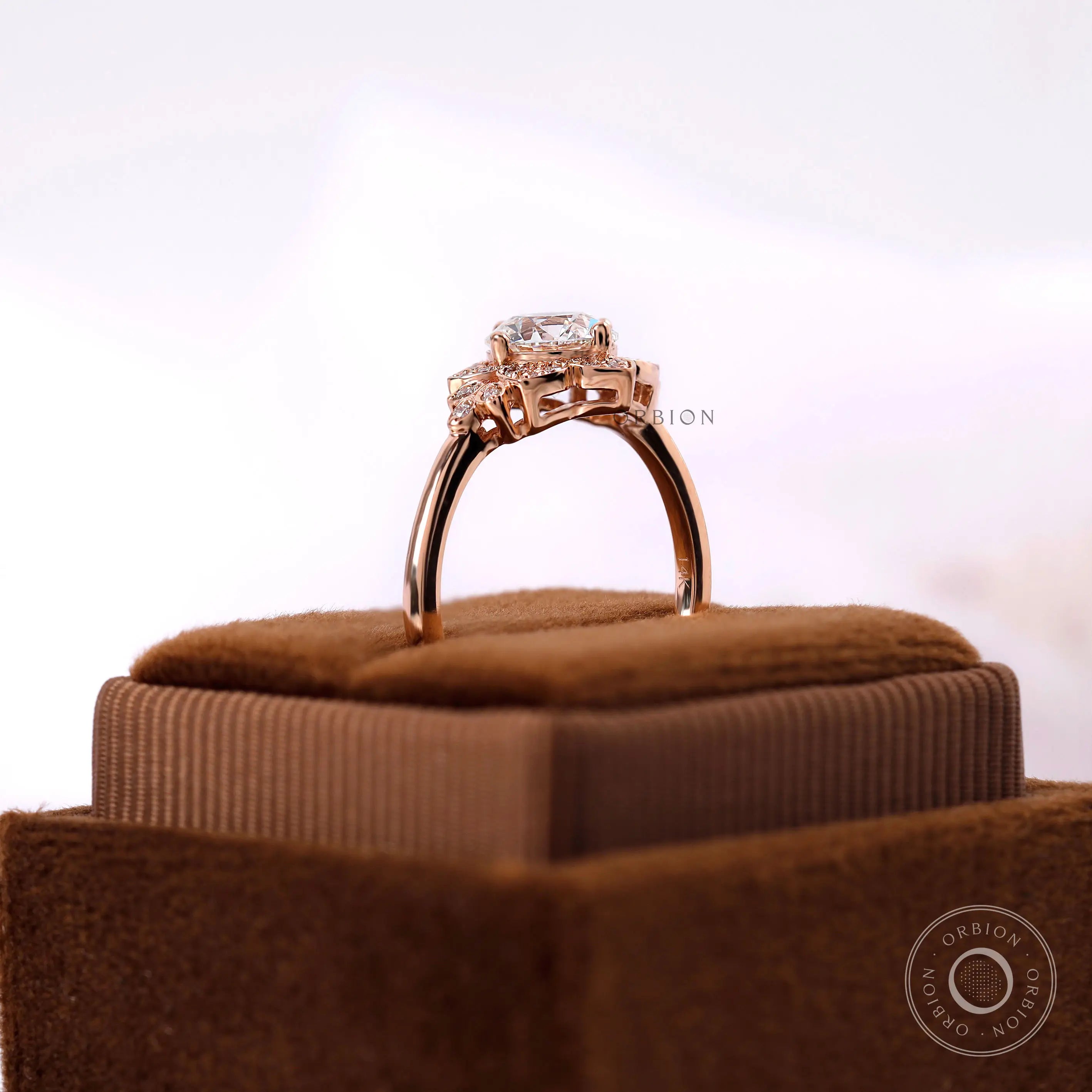 Round diamond halo ring with accent stones in rose gold band